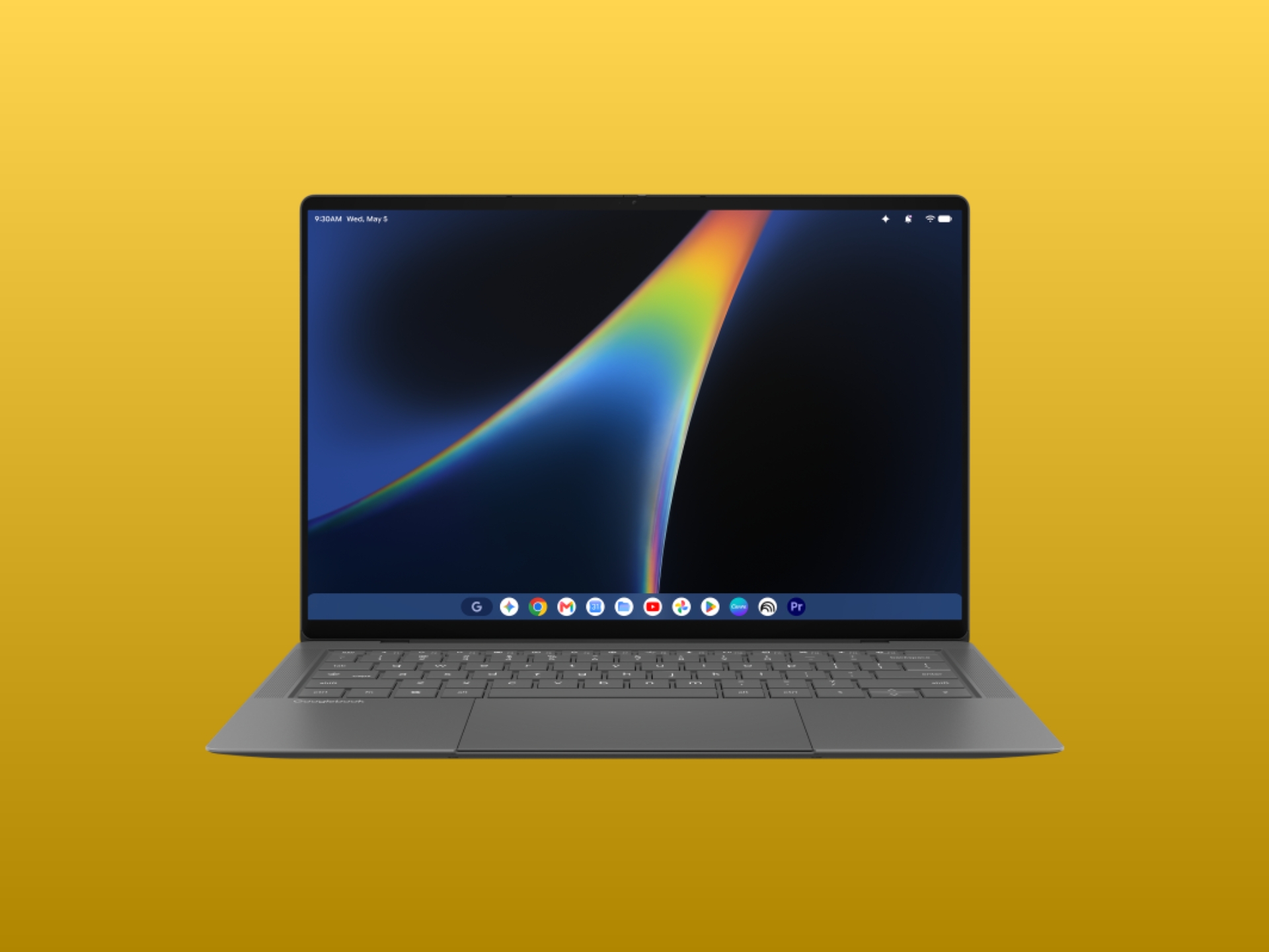 Stříbrný notebook s barevným abstraktním pozadím na obrazovce, klávesnice viditelná na žlutém pozadí.